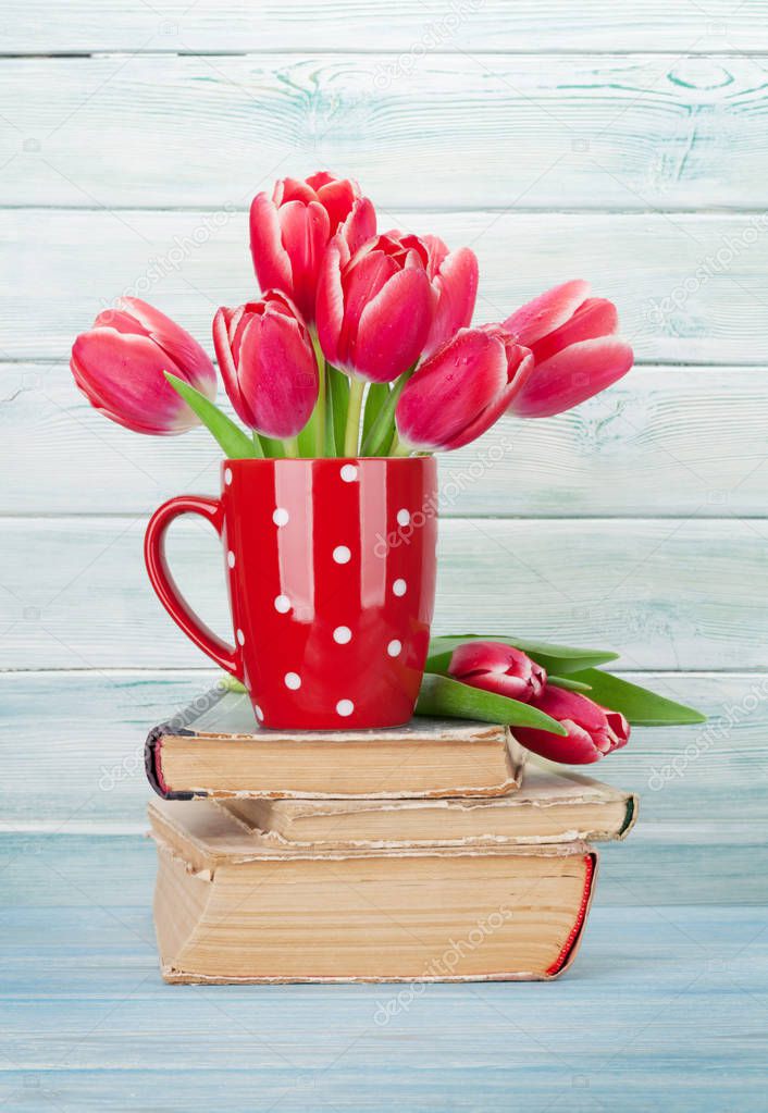 Red tulip flowers bouquet on books. Valentine's day or Easter greeting card