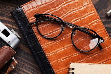 Retro vintage öğeler tablo. Fotoğraf makinesi, not defteri, gözlük. Üstten Görünüm