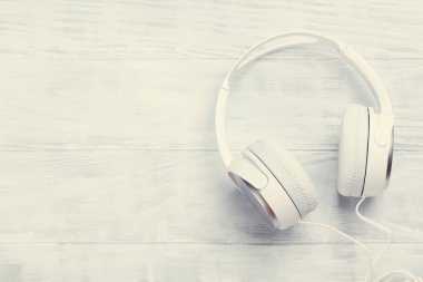 Beyaz ahşap masa üzerinde kulaklık. Üstten Görünüm kopya alanı ile. Tonda retro