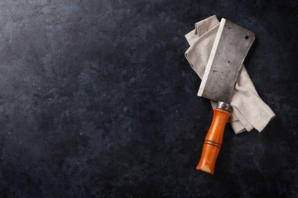 Butcher. Vintage meat knife over stone table. Top view with space for your text