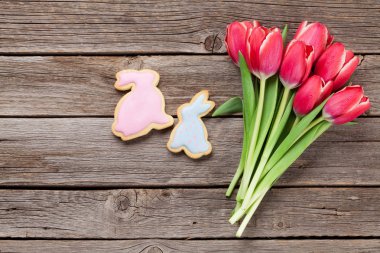 Kırmızı lale buketi ve Paskalya gingerbread çerezleri. Paskalya tebrik kartı ile yer