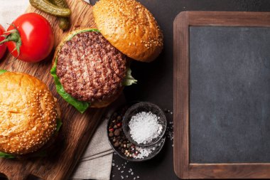 Sığır eti, domates, peynir, turşu ve marul lezzetli ızgara burger. Kopya alanı ile Üstten Görünüm