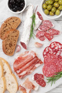 Salam, dilimlenmiş jambon, sosis, jambon, pastırma, tost, zeytin. Ahşap masa üzerinde et meze tabağı. Üstten Görünüm