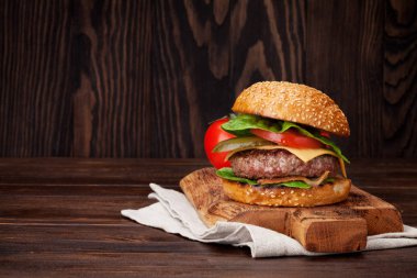 Lezzetli sığır eti, domates, peynir, salatalık, marul ile ev yapımı hamburger ızgara. Alanı ile tarifi için