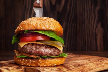 Lezzetli sığır eti, domates, peynir, salatalık, marul ile ev yapımı hamburger ızgara. Alanı ile tarifi için