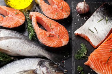 Çiğ somon balık fileto ve dorado kesme tahtası üzerinde yemek baharatlar ile