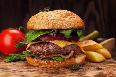 Sığır eti, domates, peynir, salatalık, marul ile lezzetli ızgara ev yapımı hamburger