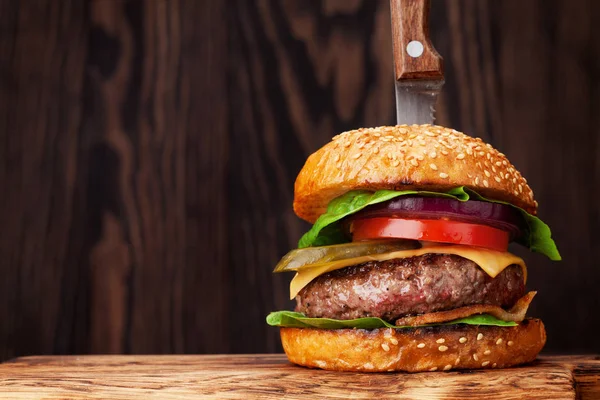 Sığır eti, domates, peynir, salatalık, marul ile lezzetli ızgara ev yapımı hamburger. Alan ile tarifi