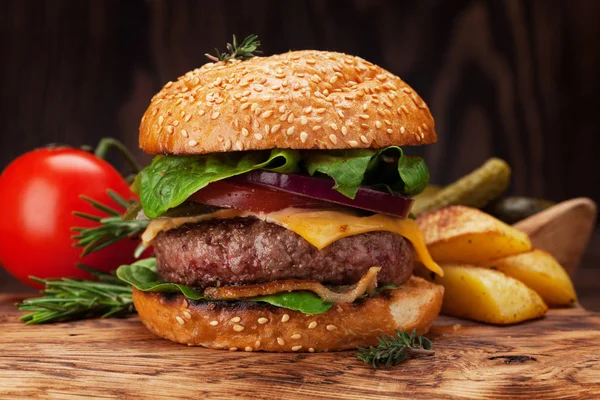 Sığır eti, domates, peynir, salatalık, marul ile lezzetli ızgara ev yapımı hamburger