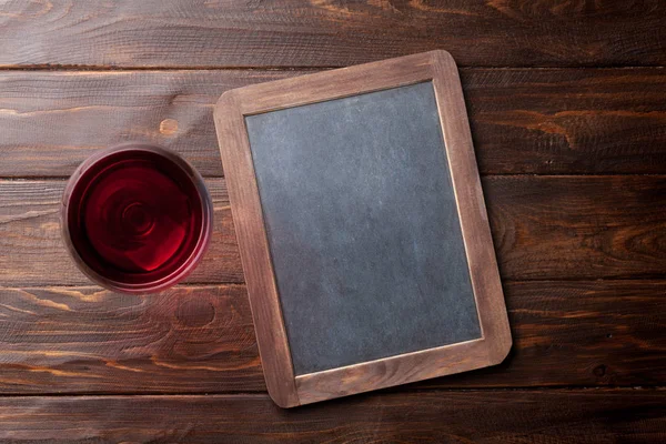 红酒杯和木桌上的黑板 带空格的顶部视图 — 图库照片