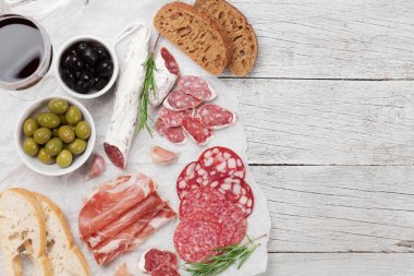 Et meze tabağı ve ahşap masa üzerinde kırmızı şarap. Kopya alanı ile Üstten Görünüm