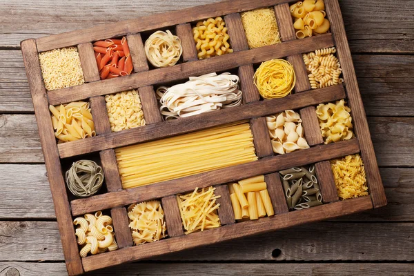 Various pasta in wooden box. Cooking concept. Top view