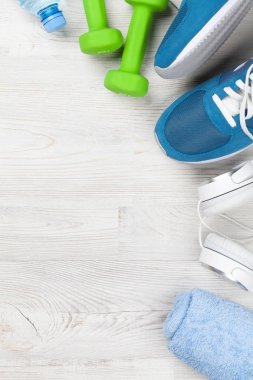 Spor ayakkabı, kulaklık, halter, su şişesi ve havlu ile fitness kavramı arka plan. Metin alanı olan Üstten Görünüm