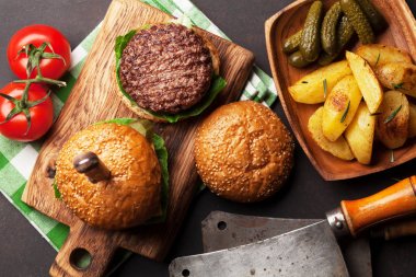 Sığır eti, domates, peynir, salatalık, marul ile lezzetli ızgara ev yapımı hamburger. Üstten Görünüm