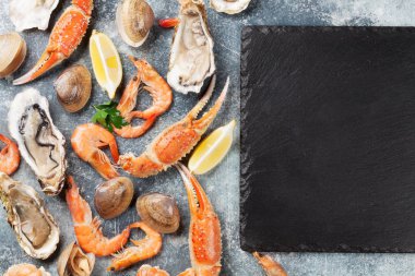 Deniz ürünleri. İstiridye, ıstakoz, istiridye. Senin metin için yer ile taş tabloda Üstten Görünüm