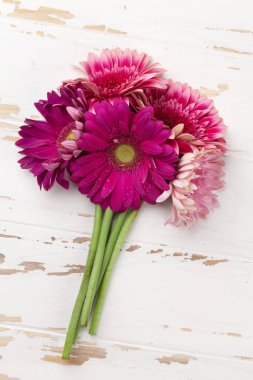 Gerbera çiçekleri buketi ahşap masa üzerinde. Üstten Görünüm