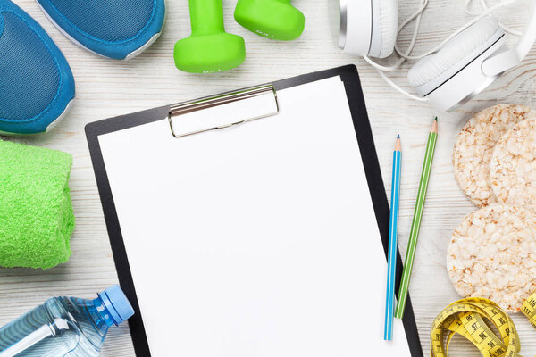 Фитнес-концепция фона с кроссовки, наушники, гантели, бутылка с водой и полотенце. Вид сверху с пространством для вашего текста

