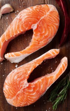 Kesme tahtasında baharatlı çiğ somon balığı bifteği. Üst görünüm