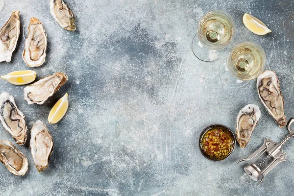 石桌上的新鲜牡蛎和白葡萄酒 带空格的顶部视图 — 图库照片