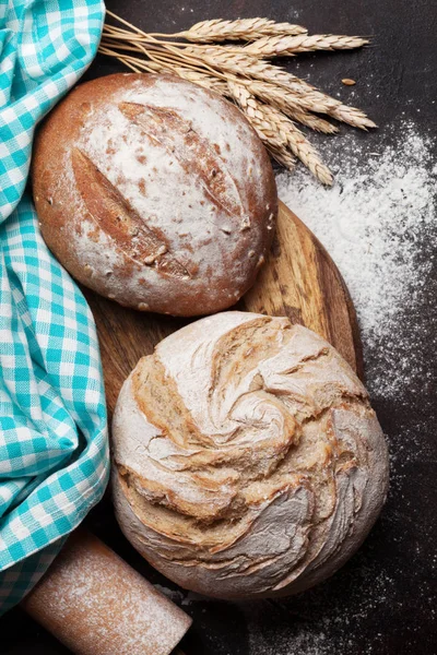 Homemade crusty bread cooking on blackboard background. Top view