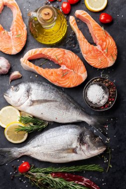 Çiğ somon balık fileto ve dorado kesme tahtası üzerinde yemek baharatlar ile. Üstten Görünüm