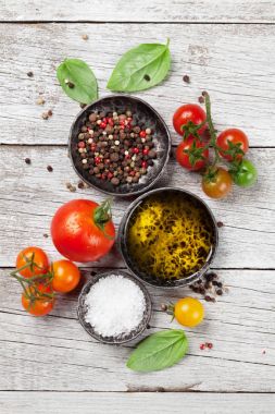 Domates, fesleğen, zeytinyağı ve baharat ahşap masa üzerinde. Pişirme kavramı. Üstten Görünüm