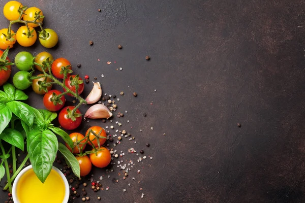 Tomatoes, basil and spices on stone table. Cooking concept. Top view with space for your text