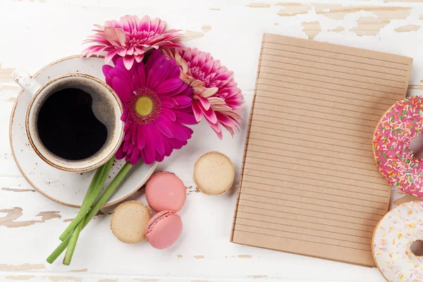 Kaffeetasse Makronen Donuts Und Gerbera Blumenstrauß Auf Weißem Holztisch Draufsicht — Stockfoto