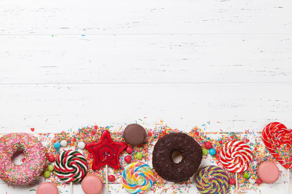 Colorful sweets. Lollipops, macaroons, candies, donuts. Top view with space for your text