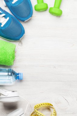 Spor ayakkabı, kulaklık, halter, su şişesi ve havlu ile fitness kavramı arka plan. Metin alanı olan Üstten Görünüm