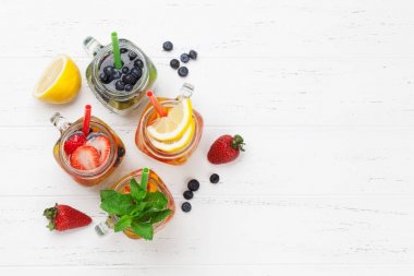 Taze limonata kavanoz ile yaz meyve ve çilek beyaz tahta masada. Üstten Görünüm alanı ile