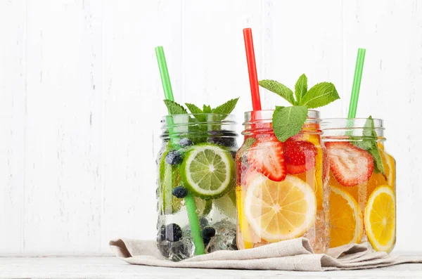 近三家自制的柠檬水罐子 配有夏日水果和浆果 — 图库照片