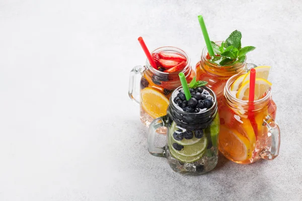 新鲜柠檬水罐子以颜色夏天果子和莓果在灰色背景 顶部看法与拷贝空间 — 图库照片