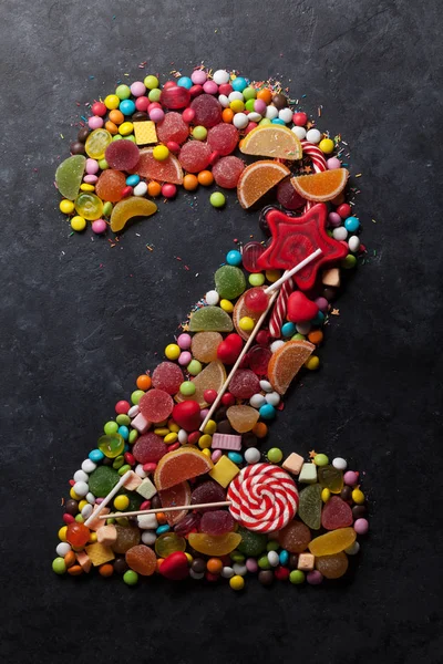 Number two made from sweet candies on dark background. Greeting card concept