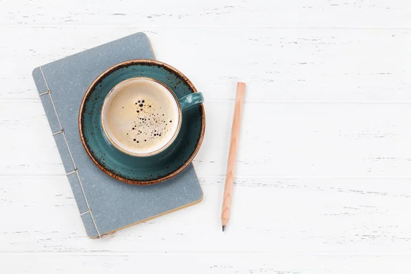 咖啡杯和记事本用铅笔放在白色的木桌上 带空格的顶部视图 — 图库照片