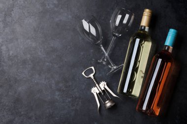 Pembe ve beyaz şarap şişeleri siyah taş masada. Kopya alanı ile Üstten Görünüm