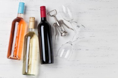 Kırmızı, pembe ve beyaz şarap şişeleri ahşap masa üzerinde. Kopya alanı ile Üstten Görünüm