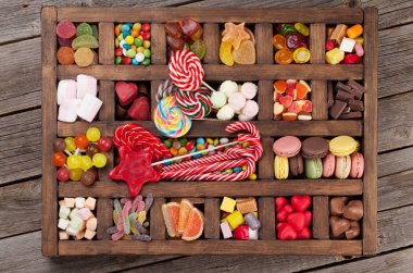 Colorful sweets box. Lollipops, macaroons, marshmallow, marmalade and candies. Top view
