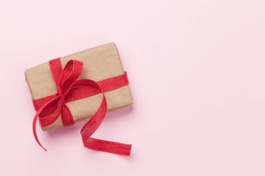 Noel ya da Sevgililer Günü hediye paketi pembe arka planda. Kopyalama alanı olan üst görünüm. Düz yatıyordu