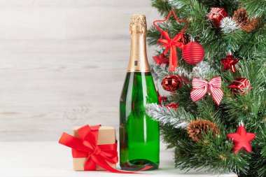 Noel tebrik kartı ile süslenmiş köknar ağacı, şampanya, hediye kutusu ve Noel kutlaması için fotokopi alanı