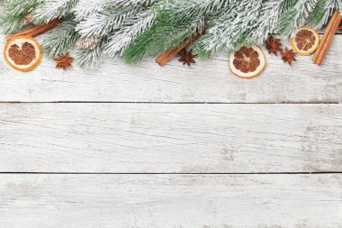 Köknar ağacı ve baharatlı Noel tebrik kartı beyaz ahşap arka planda ve Noel kutlamalarınız için alanı kopyalayın. Üst görünüm düzlüğü