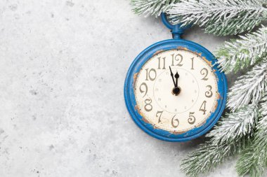 Köknar ağacı ve çalar saatin olduğu Noel tebrik kartı taştan arka planda ve yılbaşı kutlamalarınız için alanı kopyalayın. Üst görünüm düzlüğü