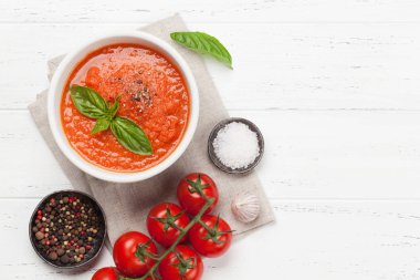 Olgun domates, salatalık ve fesleğen ahşap masada soğuk gazpacho çorbası. Üst görünüm düz kopyalama alanı ile yatıyordu