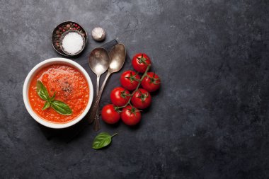 Olgun domates, salatalık ve fesleğen ile soğuk gazpacho çorbası taş masada. Üst görünüm düz kopyalama alanı ile yatıyordu