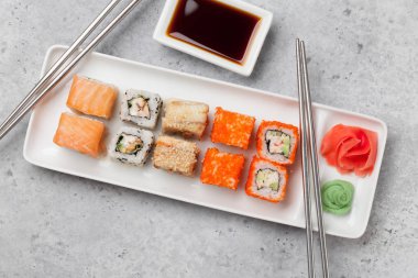 Japon Suşi seti. Sashimi, Maki ruloları. Taş arka planda plaka üzerinde