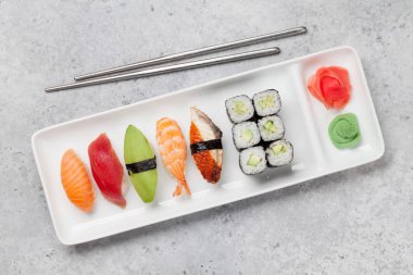 Japon Suşi seti. Sashimi, Maki ruloları. Taş arka planda plaka üzerinde