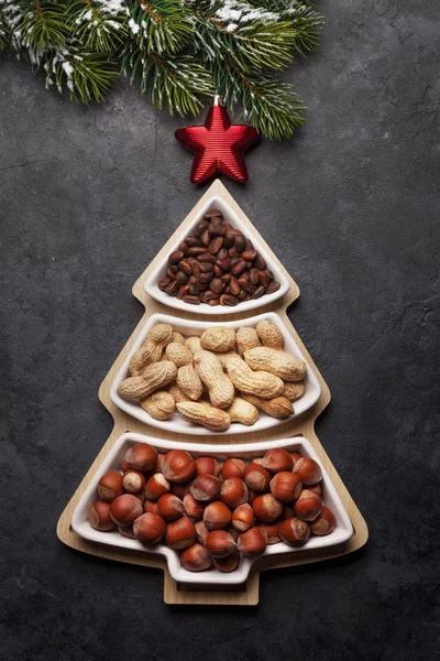 モミの木の形の箱に様々なナッツとクリスマスグリーティングカード 最上階平面 — ストック写真