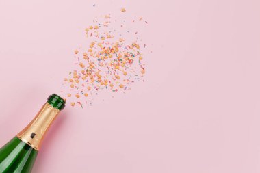 Noel tebrik kartı, şampanya ve pembe arka planda yıldız şeklinde şekerler. Üst Manzara. Selamlarınız için uzayı olan düz uzanın