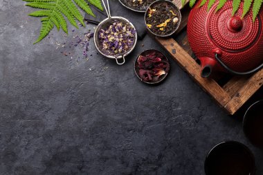 Taş masanın üzerinde farklı bitkisel ve meyveli çaylar var. Üst görünüm düzlüğü kopyalama alanı ile yatıyordu