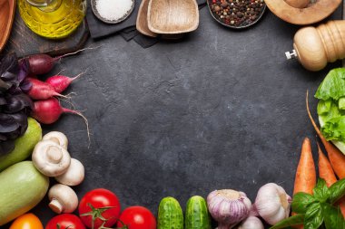 Çeşitli çiğ organik sebzeler, otlar ve baharatlar. Taze bahçe vejetaryen gıda. Kopya alanı olan taş masada üst görünüm